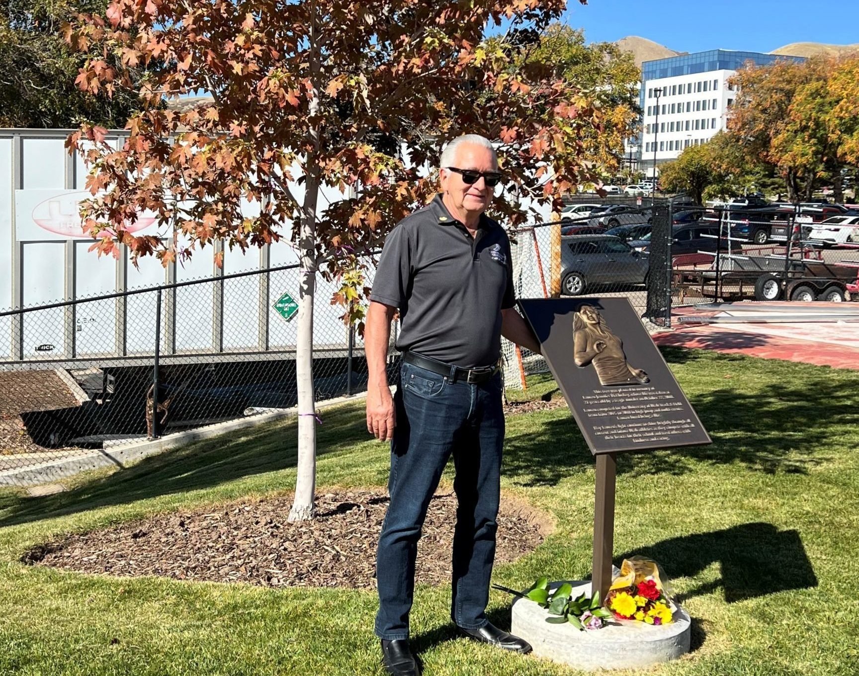 Ron Mittelhammer, Board Member standing next to Lauren McCluskey Plaque at McCarthey Family Track and Field on University of Utah's campus